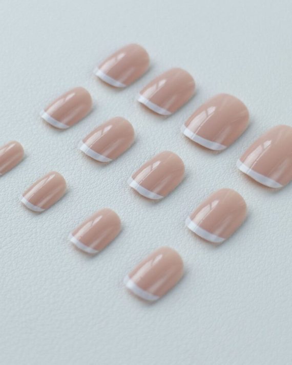 12 pcs of different sizes of eleglara triditional french tips press-on nails. They are on a light blue leather background. Item code is 0337.