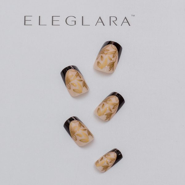 Five press-on nails with a nude base, gold botanical leaf patterns, and glossy black French tips, arranged on a white background with the Eglara Beauty logo.