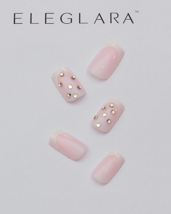 Five short square press-on nails with light pink base, white french tips, and gold rhinestone clusters on some, arranged on a white background with the Eleglara logo, glossy finish showcasing the cute, glam design.