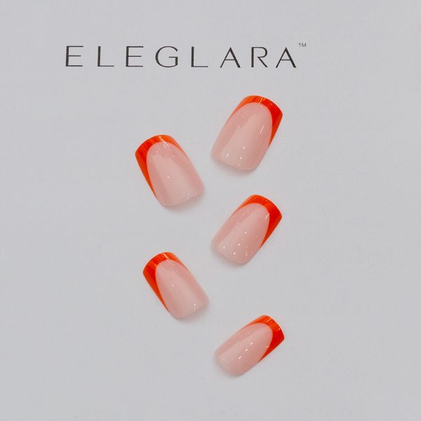 Five short square press-on nails with vibrant orange french tips on a creamy nude base, arranged neatly on a white background with the Eleglara Beauty logo, glossy finish highlighting the bold, cute design for fall chic.